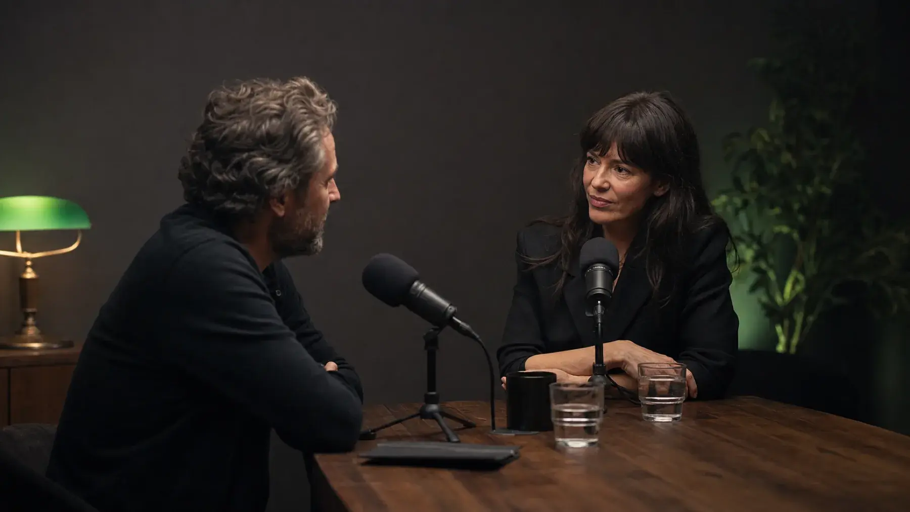 Two people recording a thoughtful interview in a dark studio